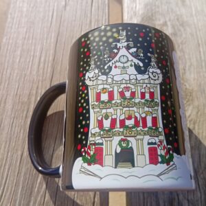 Taza de porcelana con interior negro y diseño de la Plaza Consistorial de Pamplona en Navidad, con nieve, luces y decoración navideña, diseño exclusivo de ButtiBou Pamplona. Porcelain mug with black interior featuring Pamplona’s City Hall Square at Christmas, with snow, lights, and festive decorations, exclusive design by ButtiBou Pamplona.