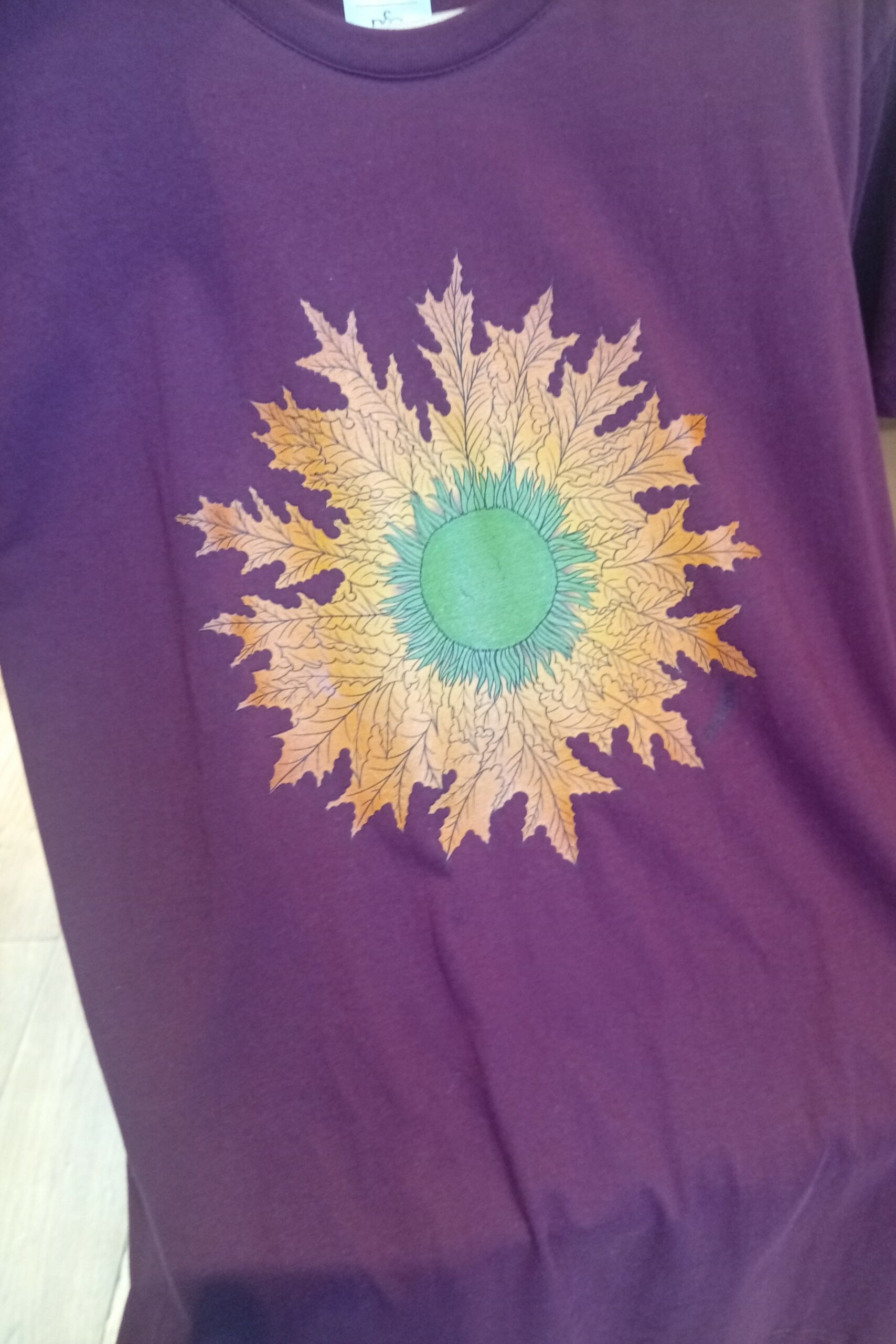 Camiseta Eguzkilore color granate – comodidad, estilo y tradición navarra en una prenda única de ButtiBou Pamplona.  Natural color Eguzkilore t-shirt – comfort, style, and Navarrese tradition in a unique ButtiBou Pamplona design camiseta Eguzkilore color natural de ButtiBou Pamplona, algodón suave y transpirable, manga corta y estampado de la flor del sol, símbolo navarro de protección. Natural color Eguzkilore t-shirt by ButtiBou Pamplona, soft breathable cotton, short sleeves, exclusive sun flower print, Navarrese protection symbol