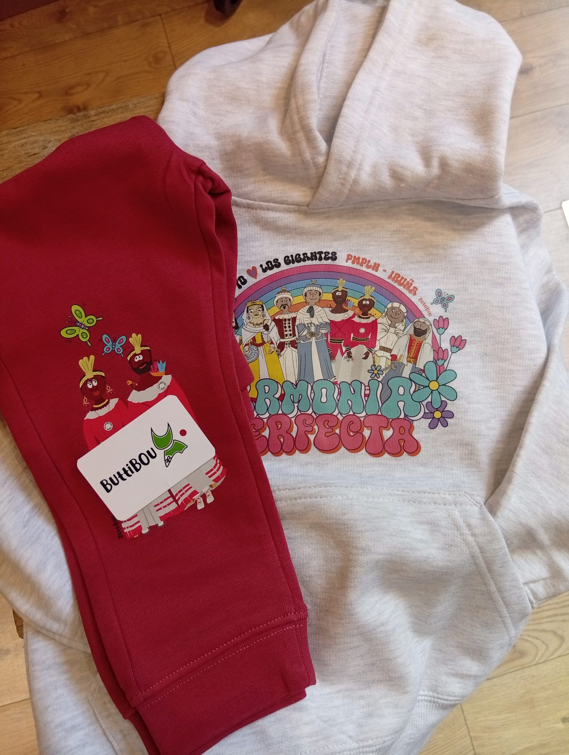 Conjunto Gigantes en Armonía Teja, inspirado en los gigantes de Pamplona. Diseño alegre, cómodo y exclusivo de ButtiBou Pamplona. Conjunto infantil Gigantes en Armonía Teja de ButtiBou Pamplona con sudadera gris y pantalón estampado de gigantes y mariposas.