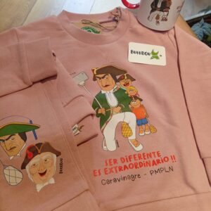Conjunto infantil rosa de algodón orgánico con Caravinagre y la frase “Ser diferente es extraordinario”, diseño exclusivo de ButtiBou Pamplona. Pink organic cotton kids set featuring Caravinagre and the phrase “Being different is extraordinary,” exclusive design by ButtiBou Pamplona.