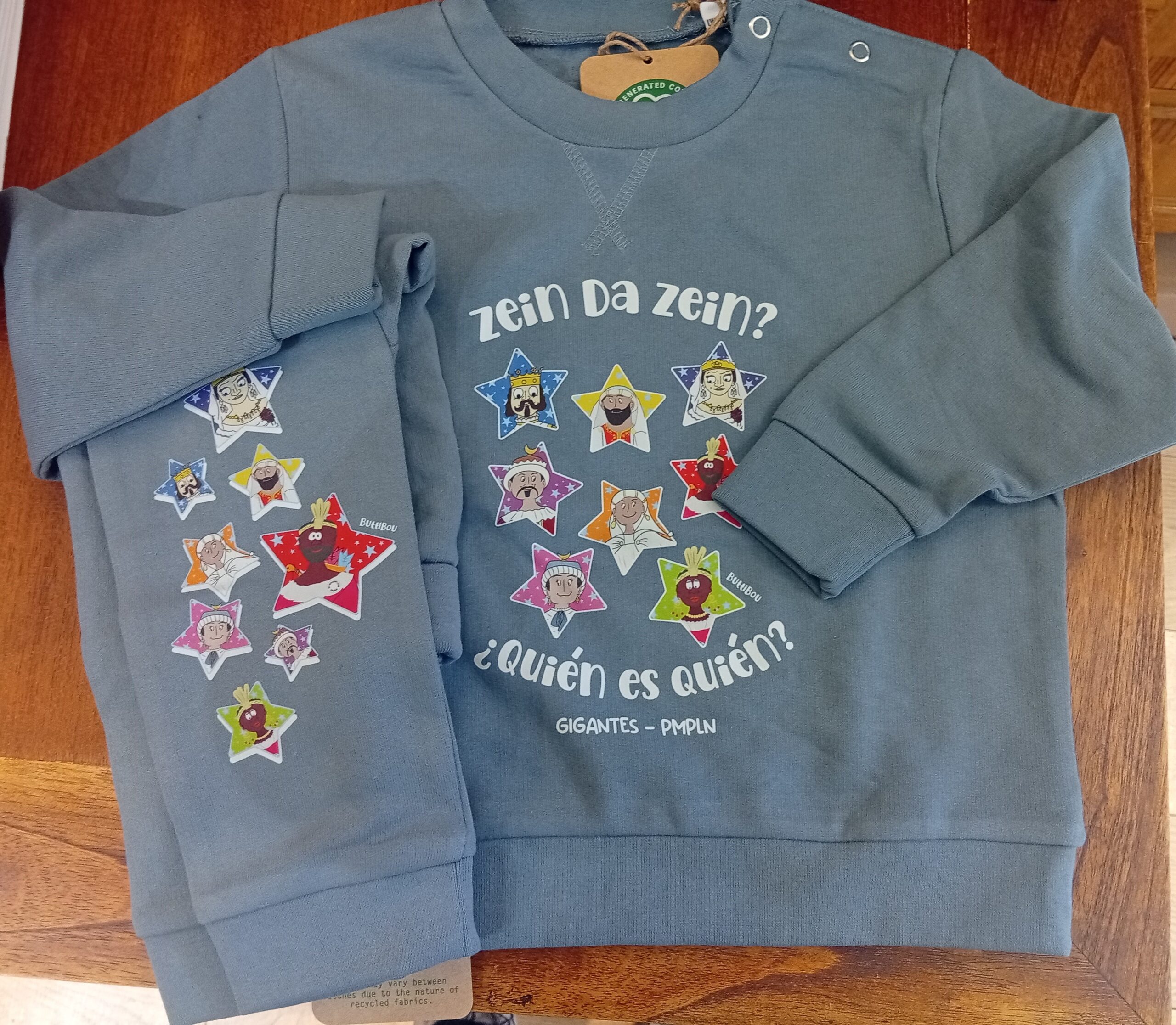 Conjunto azul con los Gigantes de Pamplona entre estrellas. Comodidad, color y alegría en una prenda única. Blue set with the Giants of Pamplona among stars. Comfort, color, and joy in one unique outfit. Conjunto infantil azul con los Gigantes de Pamplona dentro de estrellas, de algodón orgánico, ButtiBou Pamplona. Blue kids’ outfit with Pamplona Giants inside stars, made of organic cotton, ButtiBou Pamplona