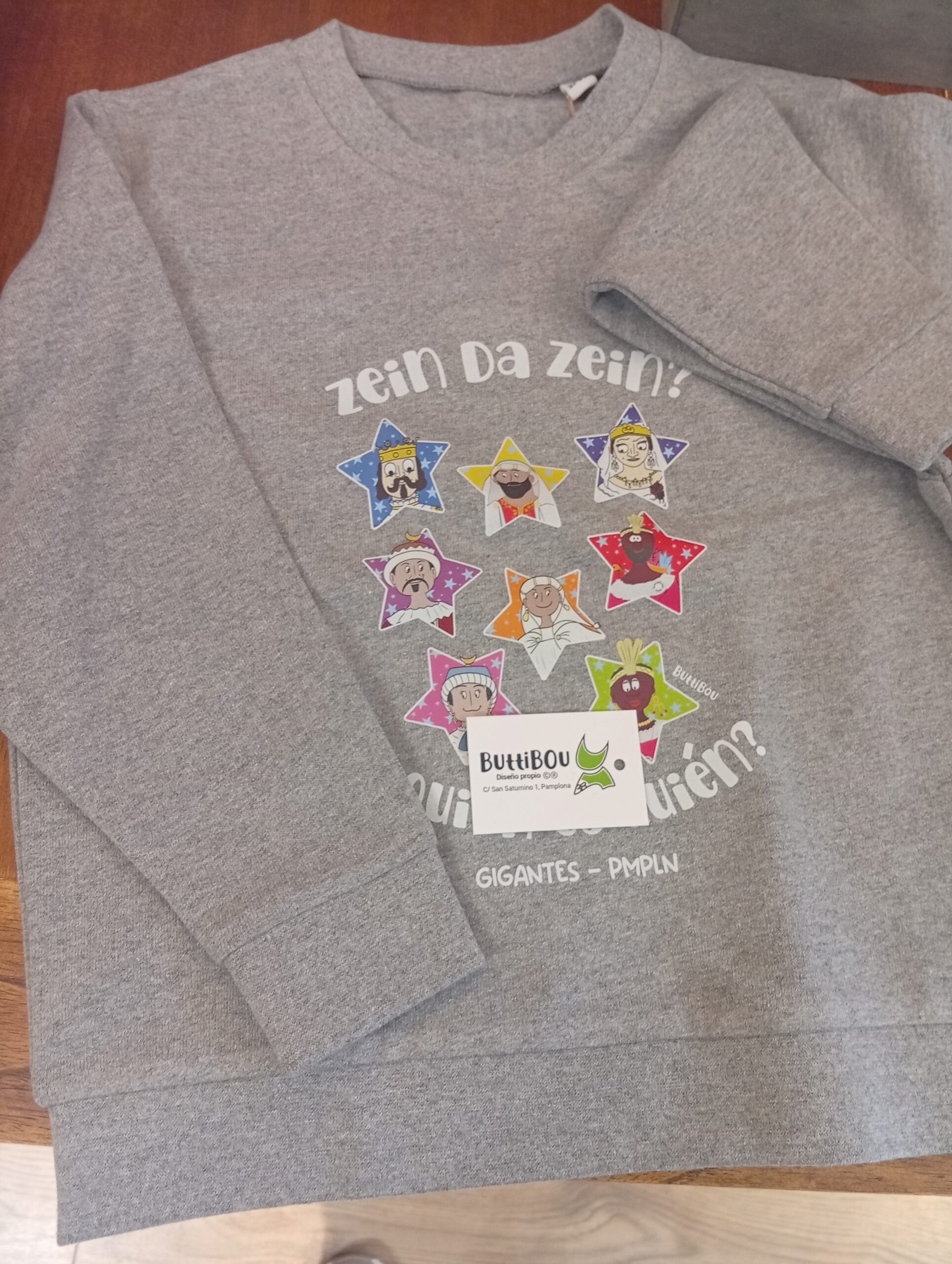 Sudadera gris con los Gigantes de Pamplona, comodidad y estilo con un toque de la magia de Pamplona. Gray sweatshirt with the Giants of Pamplona, comfort and style with a touch of Pamplonese magic Sudadera infantil gris con estampado de los Gigantes de Pamplona dentro de estrellas, diseño exclusivo de ButtiBou Pamplona en algodón orgánico .Gray kids’ sweatshirt with Pamplona Giants printed inside stars, exclusive ButtiBou Pamplona organic cotton design